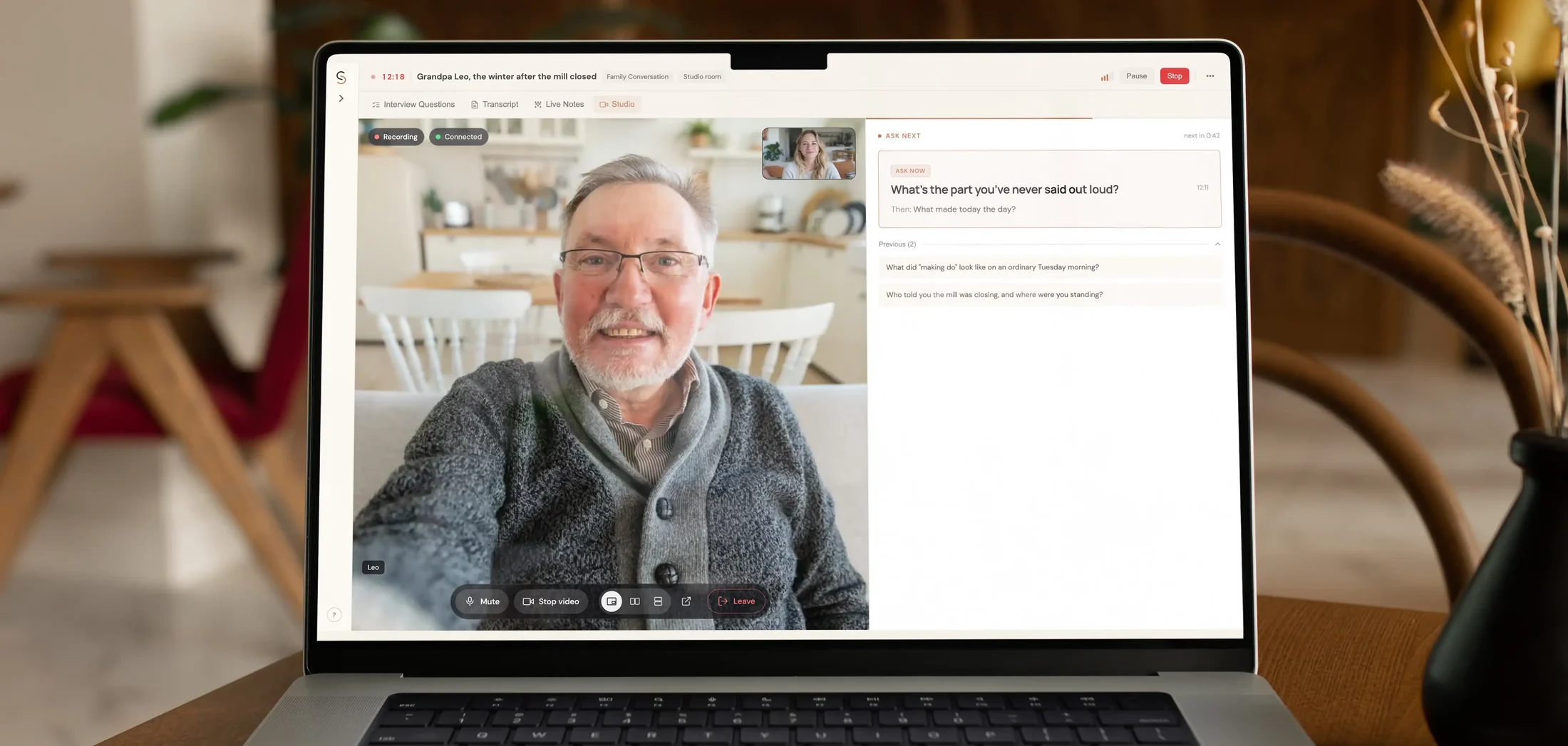 A laptop on a dining table showing a StorySeeker session in progress: Grandpa Leo on camera, and the next question waiting on the right.